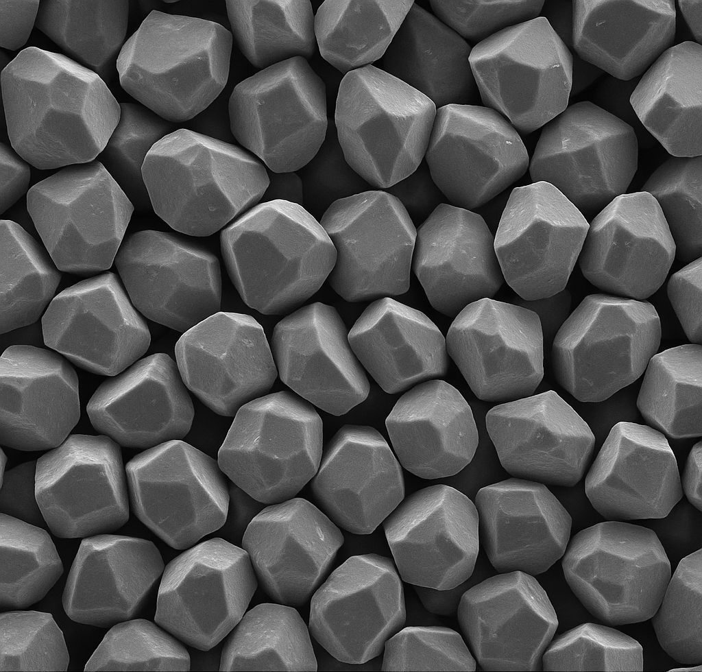 A high-resolution microscopic image of zircon powder particles, showcasing their crystalline structure and uniform size distribution.